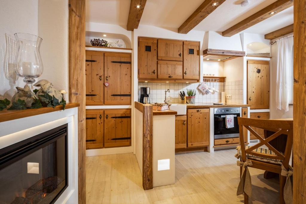 a kitchen with wooden cabinets and a fireplace at Ferienwohnungen Reich in Schönau am Königssee