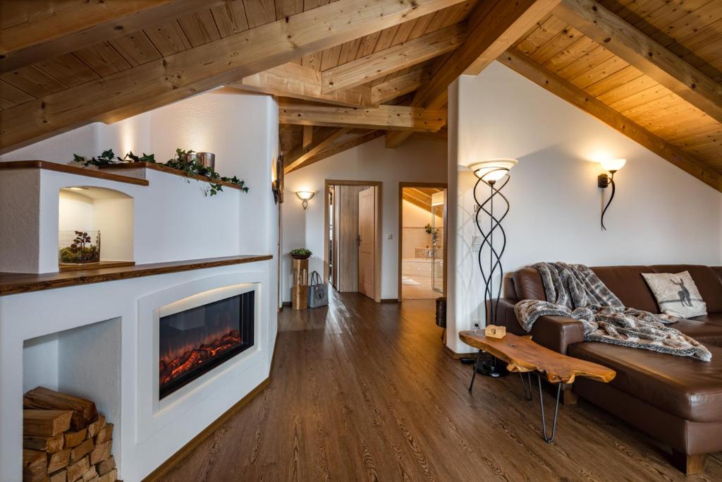 a living room with a fireplace and a couch at Ferienwohnungen Reich in Schönau am Königssee