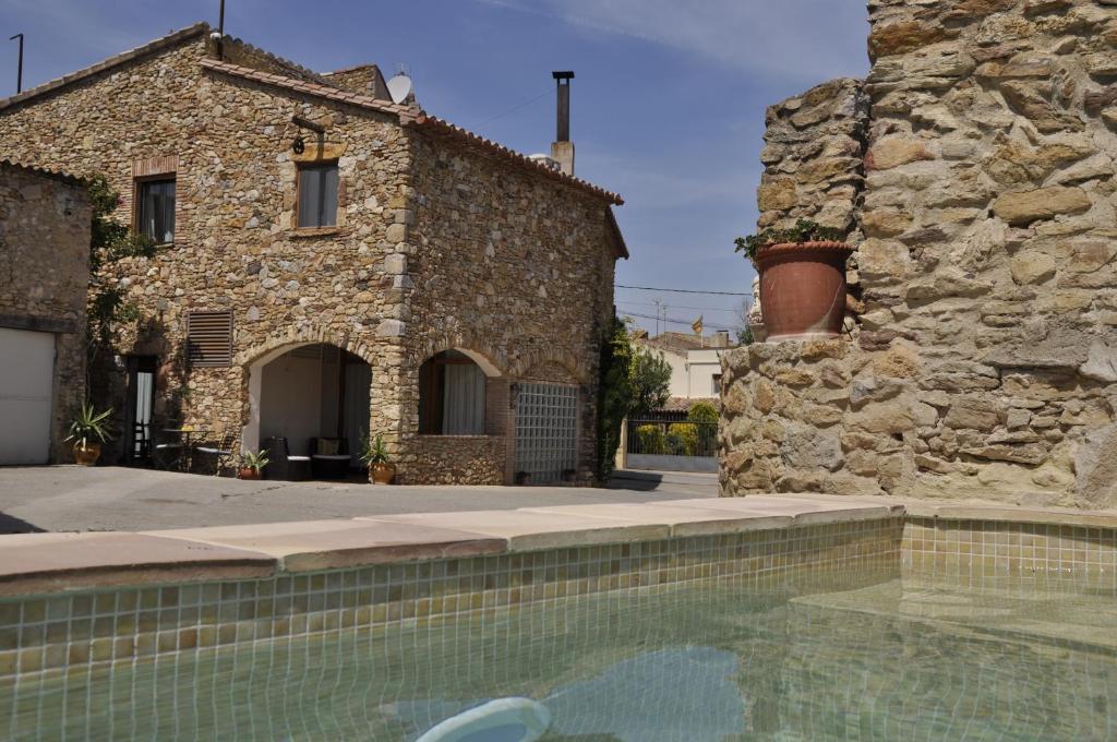 a house with a swimming pool in front of a building at Can Barrull-Costa Brava-Emporda in San Felíu de Boada