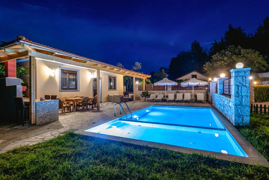 una villa con piscina por la noche en Villa Rafaella2, en Koskinou