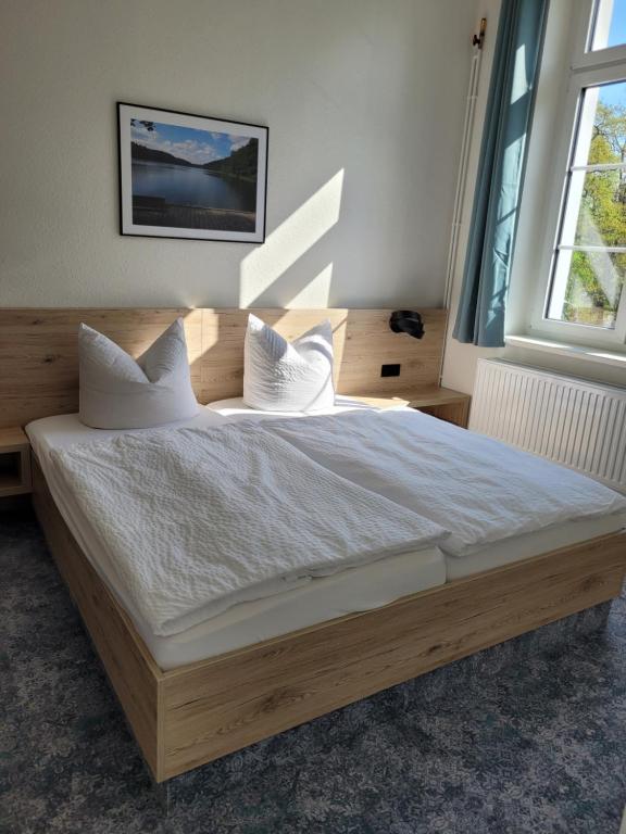 a bedroom with a large bed with white sheets and pillows at Pension zum Kleistpark in Frankfurt Oder