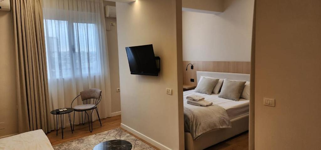 a bedroom with a bed and a tv on the wall at Signature Idea hotel in Tirana