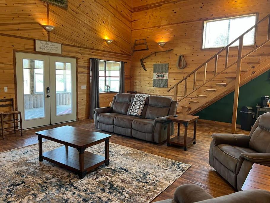 un soggiorno con divani e una scala di Strawberry River Ranch Cabin On 700 Acre Ranch a Horseshoe Bend