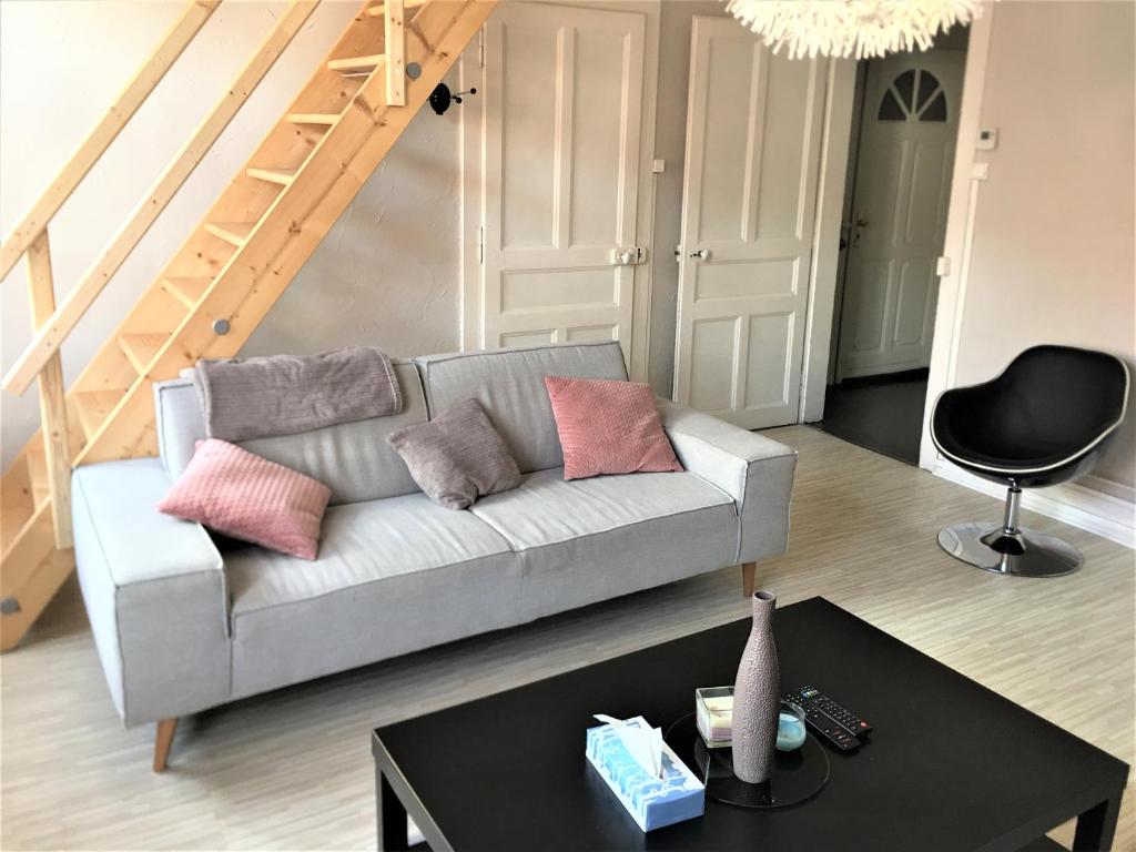 a living room with a couch and a table at Appartement 3 pièces pleins de charmes (Virginie) in Montbéliard