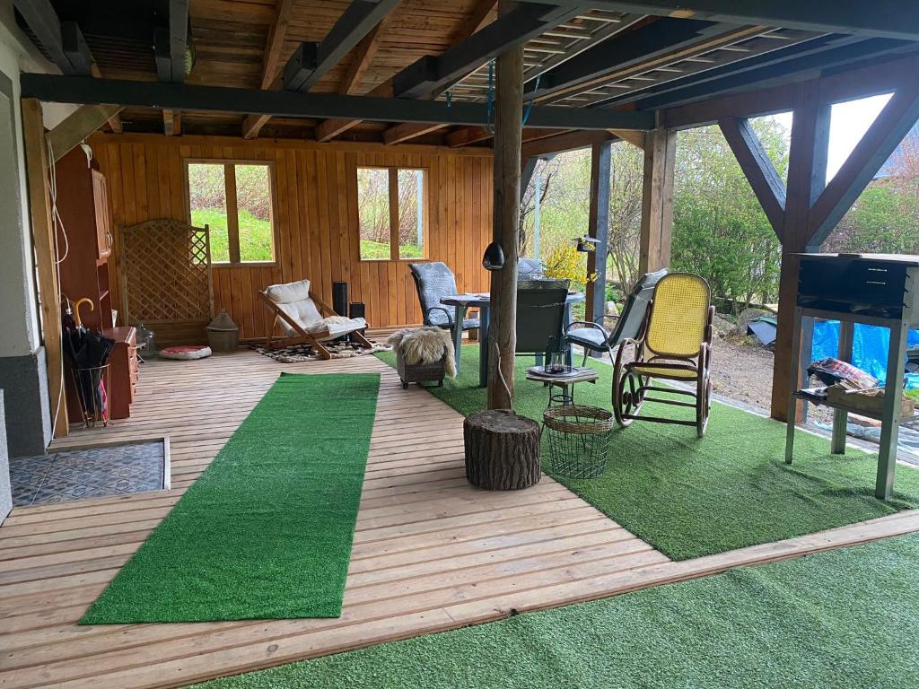 a living room with a deck with green grass at Petit Appartament in Kowary