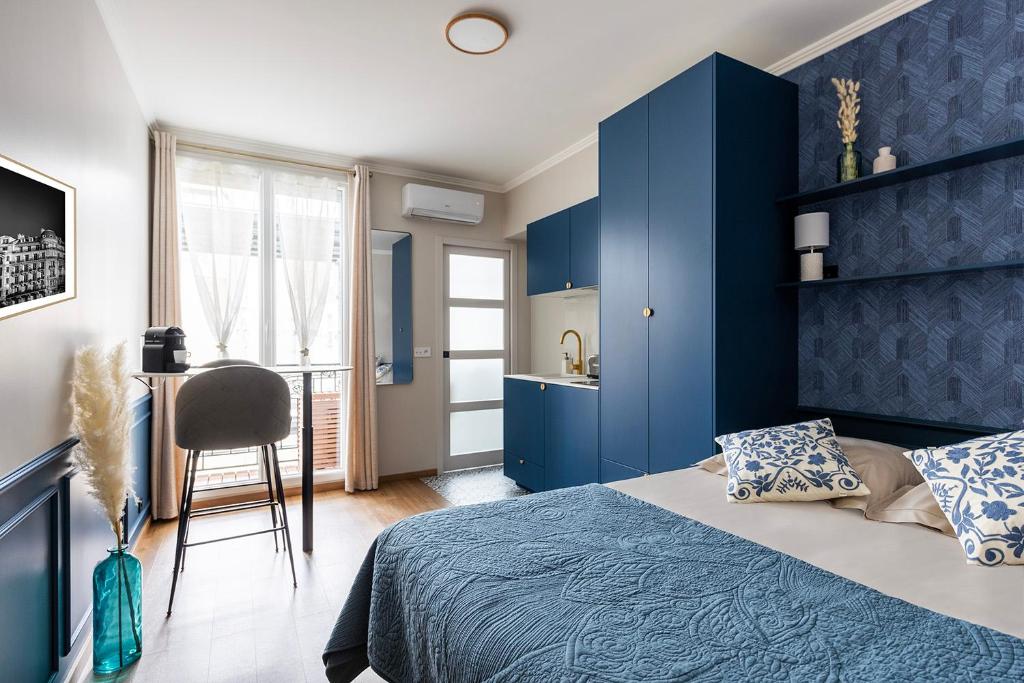 a bedroom with blue walls and a bed and a desk at Résidence Courcelle in Levallois-Perret