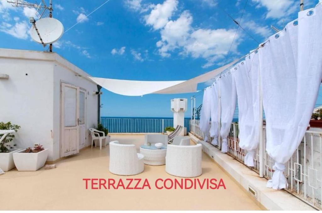 ポリニャーノ・ア・マーレにあるAmoredimare Casa Vacanzeの海の景色を望むバルコニー(白い椅子付)