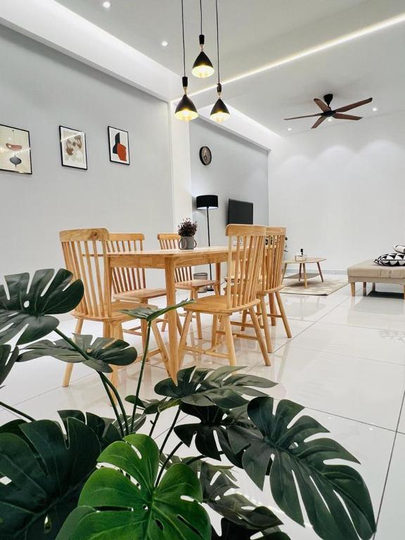 - un salon avec une table, des chaises et une plante dans l'établissement Inn Homestay 1st Floor Unit, à Teluk Intan
