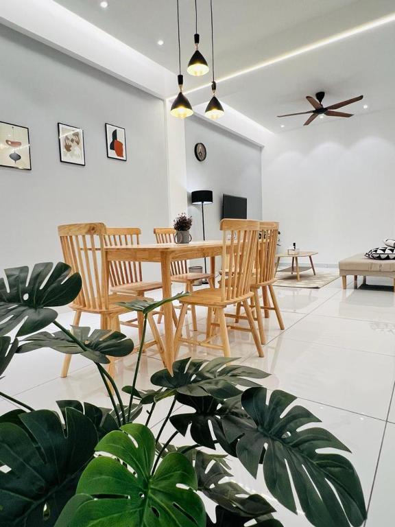 テロック・インタンにあるInn Homestay 1st Floor Unitのリビングルーム(テーブル、椅子、植物付)