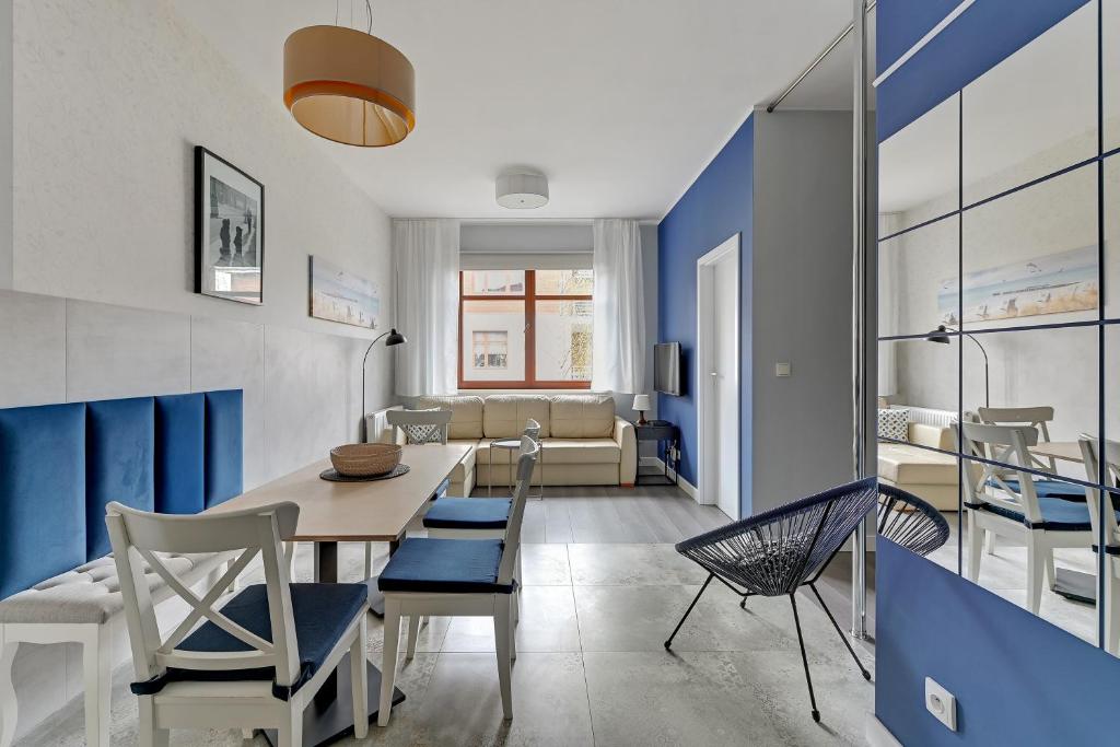 a dining room with blue walls and a table and chairs at Apartament Neptun Park Gdansk Jelitkowo by Grand Apartments in Gdańsk