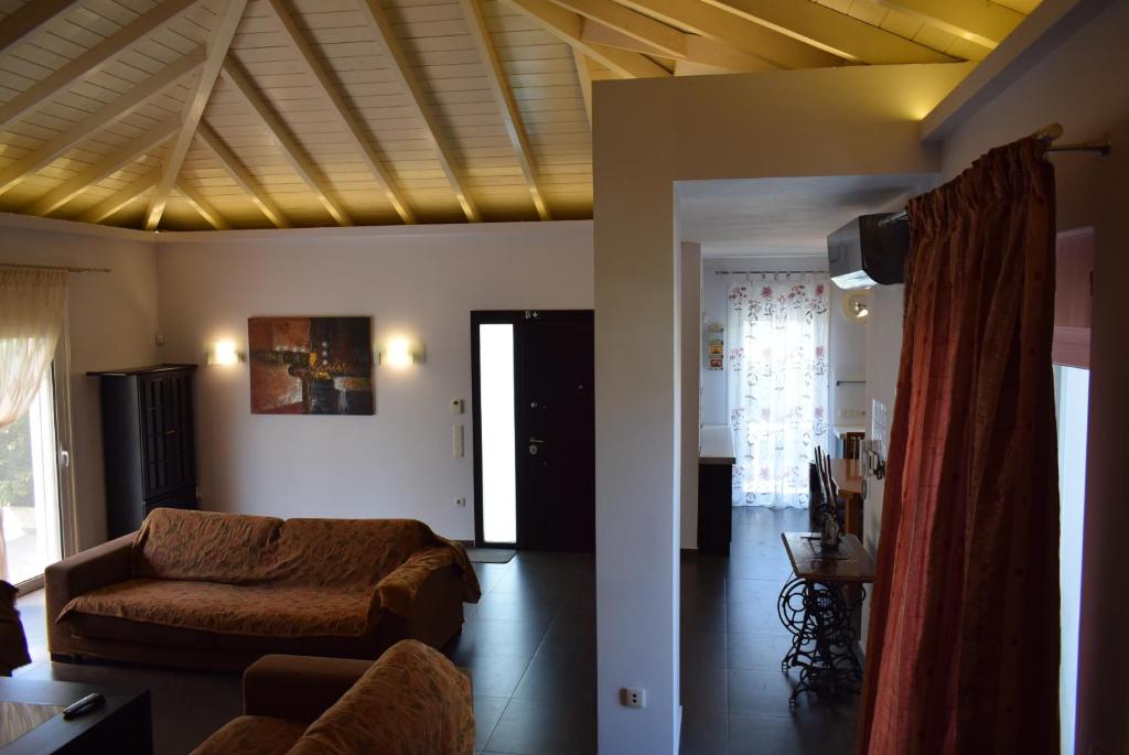 ein Wohnzimmer mit einem Sofa und einer Decke in der Unterkunft adonia villa in Levkákia