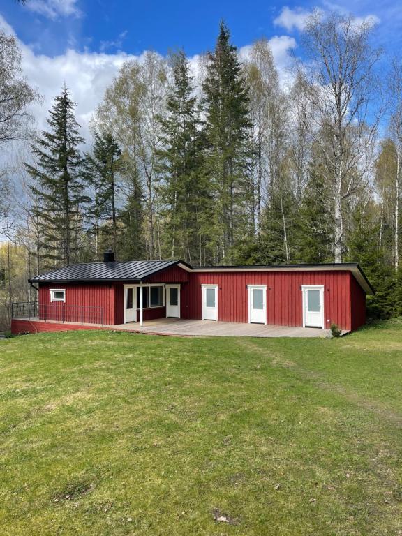 a red barn with white doors in a field at Emakaru Puhkemaja in Otepää