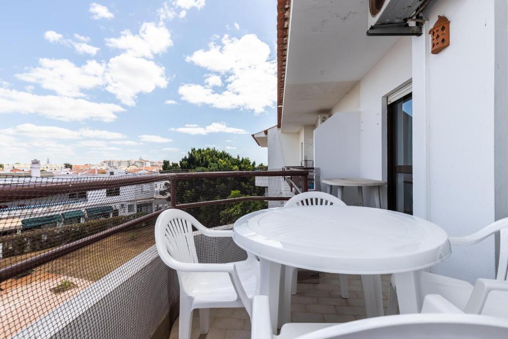 d'un balcon avec vue doté d'une table et de chaises blanches. dans l'établissement Apartamento MANTAMAR by ALGARVEMANTA, à Manta Rota