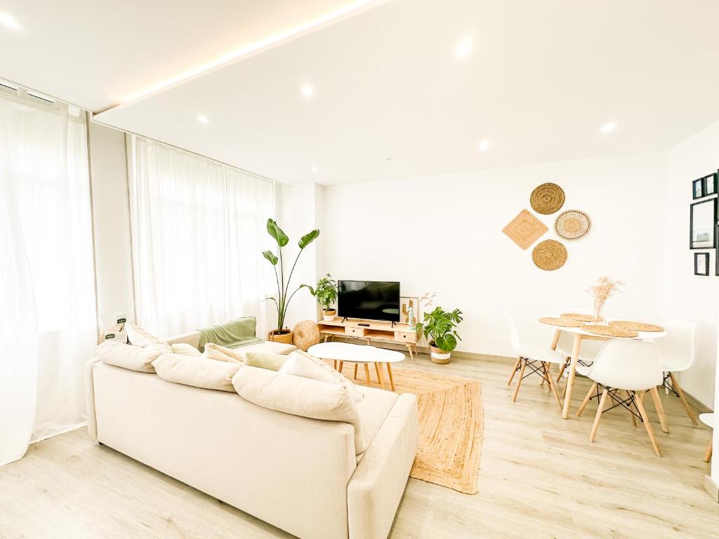 a white living room with a couch and a table at A Lobeira Grande by ALÔGA in Cee