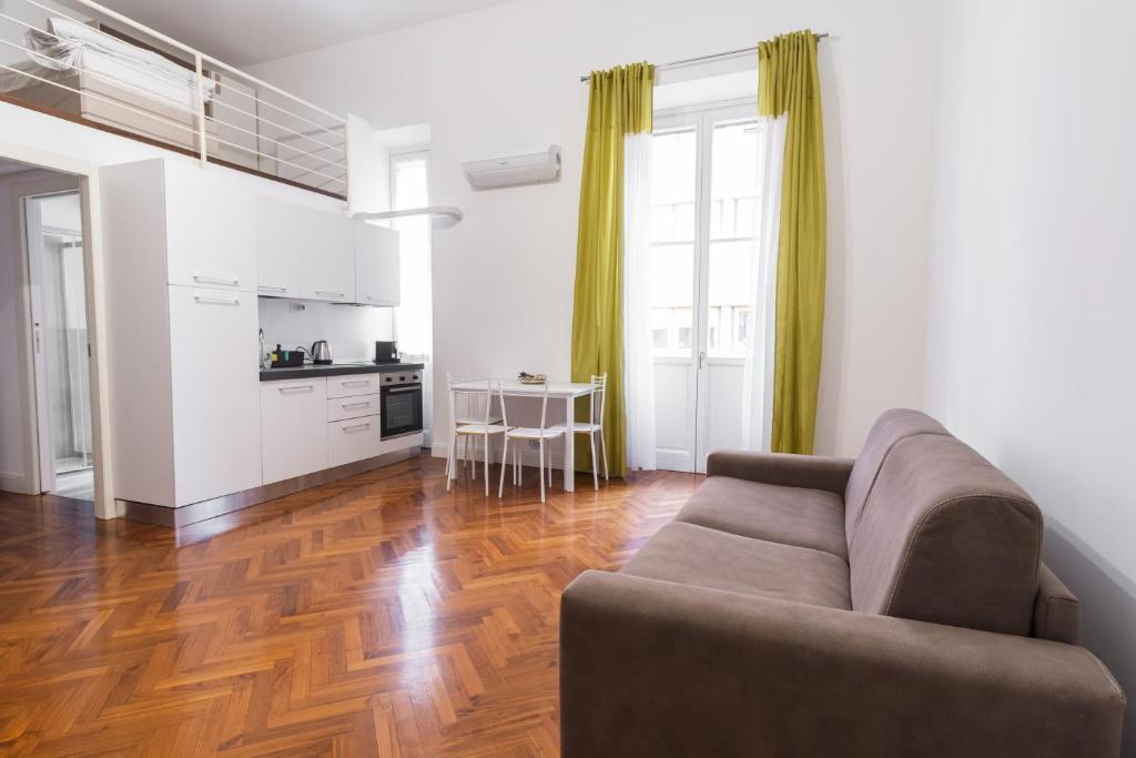 Il comprend un salon avec un canapé et une cuisine. dans l'établissement Loft via morosini centro Varese - IXIHOME, à Varèse