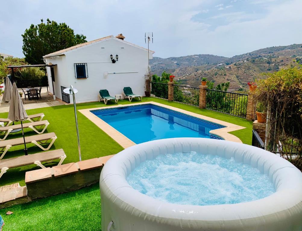 een achtertuin met een grote hot tub in de tuin bij Villa en Frigiliana con Piscina y Jacuzzi in Frigiliana
