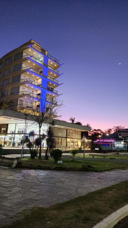 a building with blue lights on the side of it at Departamento Pinamar Centro Status Tower in Pinamar