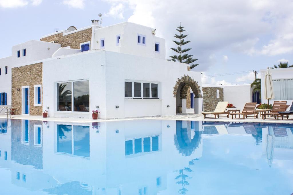 a villa with a pool in front of a house at Naxos Holidays in Naxos Chora