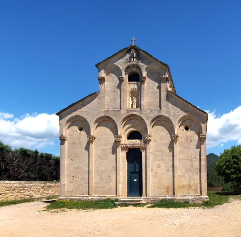 an old church with a cross on top of it at Résidence CATALINA in Saint-Florent