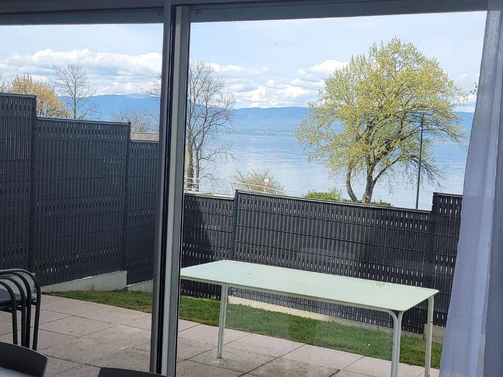 a bench on a balcony with a view of the water at Appart Thonon-Corzent in Anthy