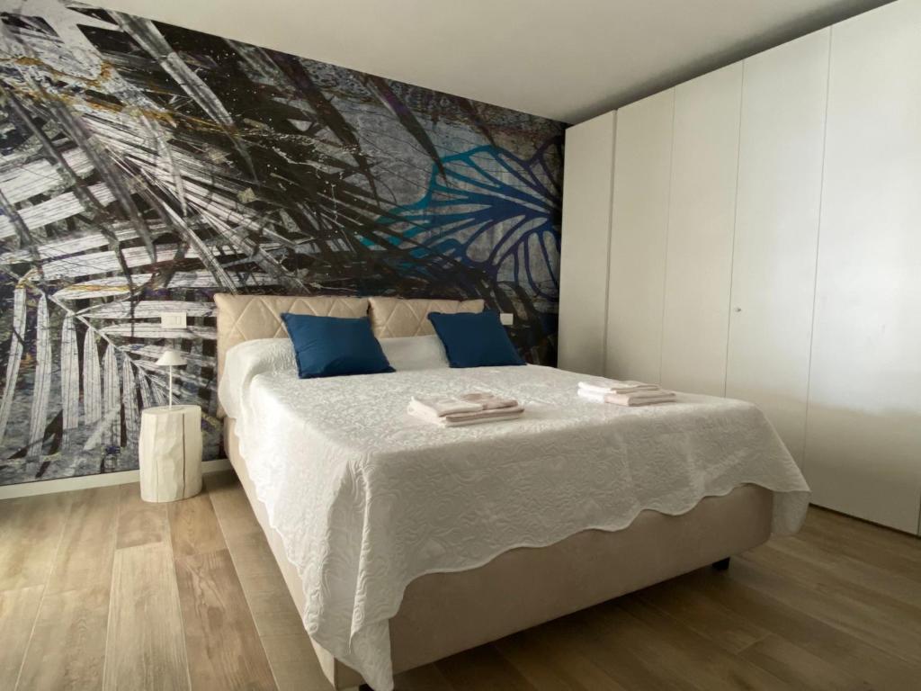 a bedroom with a bed with a painting on the wall at BOUTIQUE HOME LIGNANO in Lignano Sabbiadoro