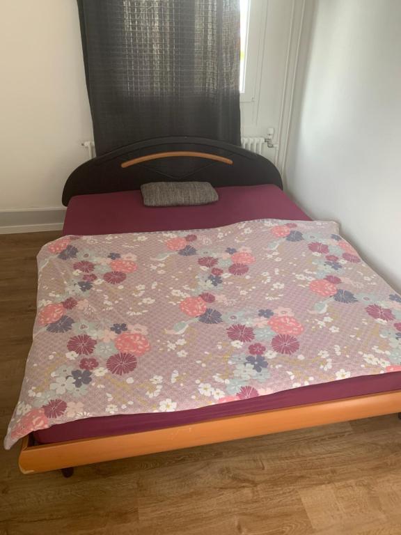 a bed in a room with a floral bedspread on it at Budget2024 in Amriswil