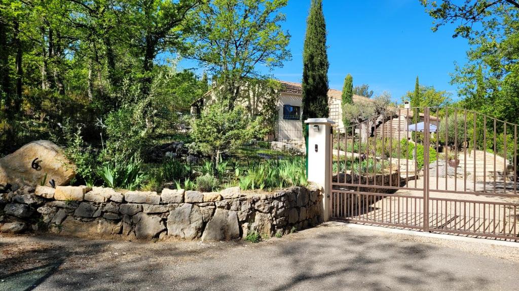 una casa con una recinzione e un muro di pietra di Maison de 3 chambres avec piscine partagee jardin clos et wifi a Mons a Mons