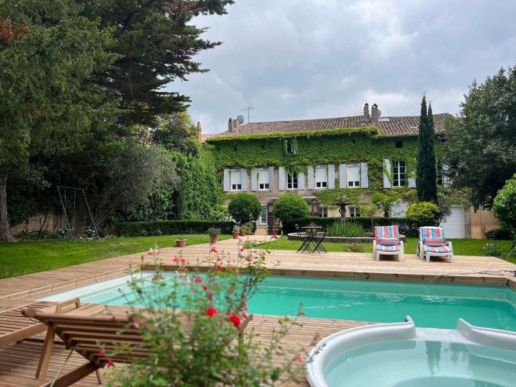 a house with a swimming pool in front of a yard at Maison Riquet in Castelnaudary
