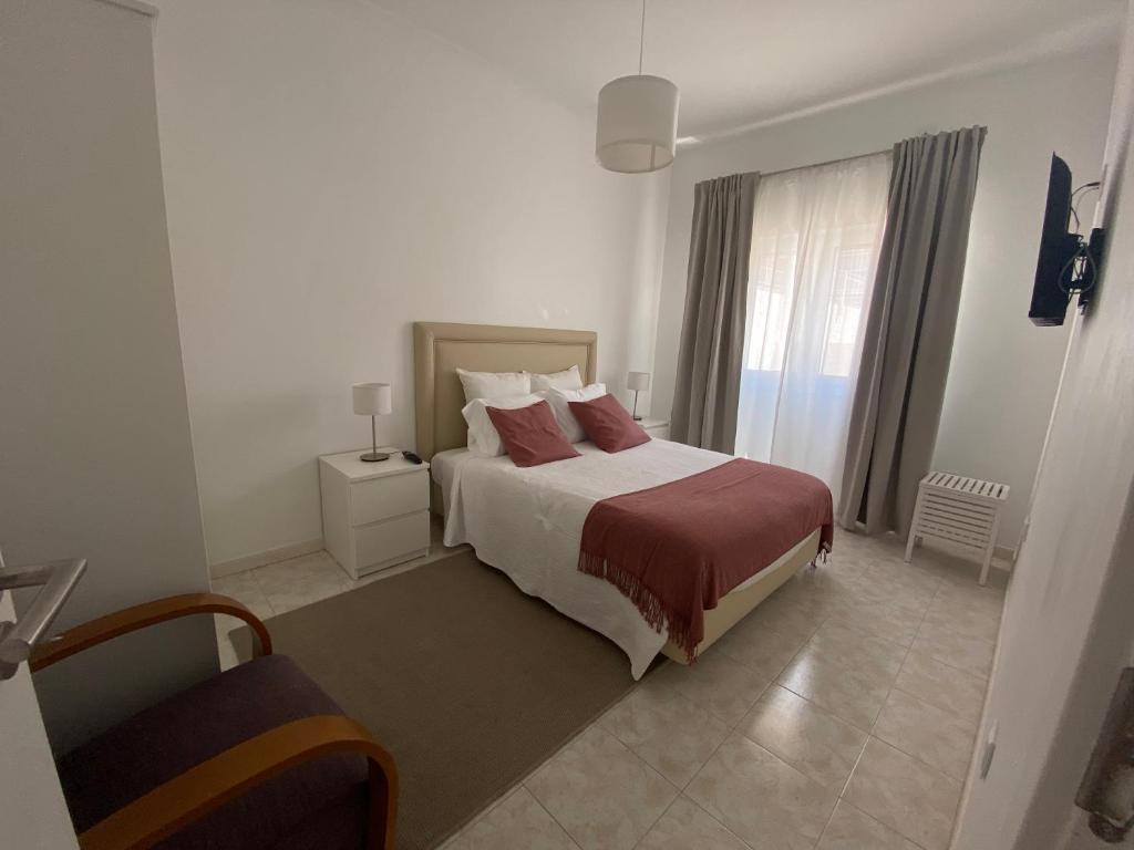 a hotel room with a bed and a window at Guest House in Faro