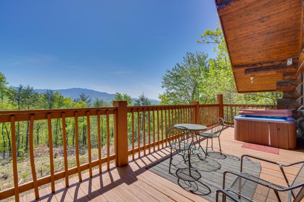 una terraza de madera con mesa y sillas. en Smoky Mountain Vacation Rental with Hot Tub! en Gatlinburg