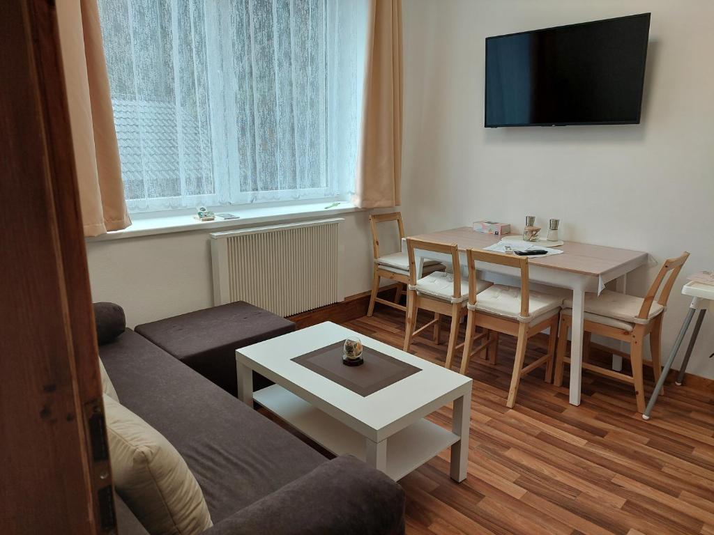 een woonkamer met een bank en een tafel bij Kopretina in Benešov nad Černou