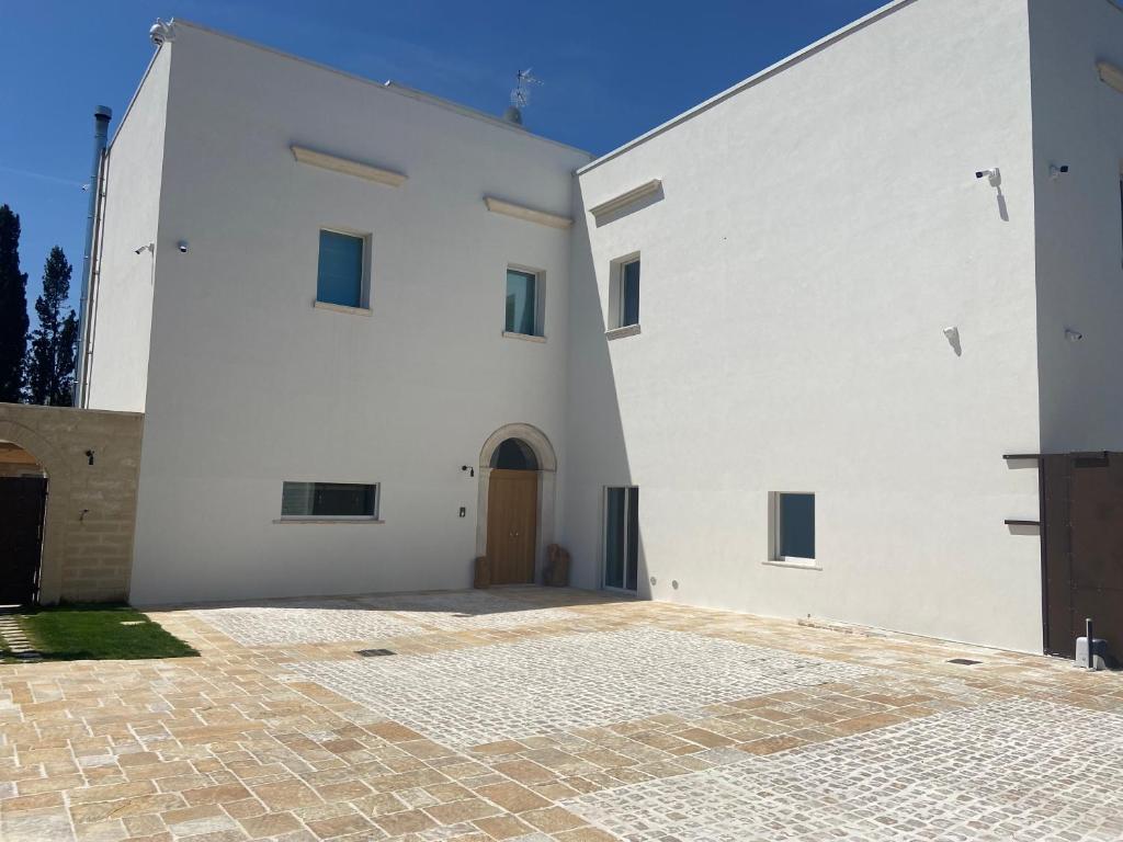 - un bâtiment blanc avec une porte et une cour dans l'établissement Palazzo Momi, à Bari