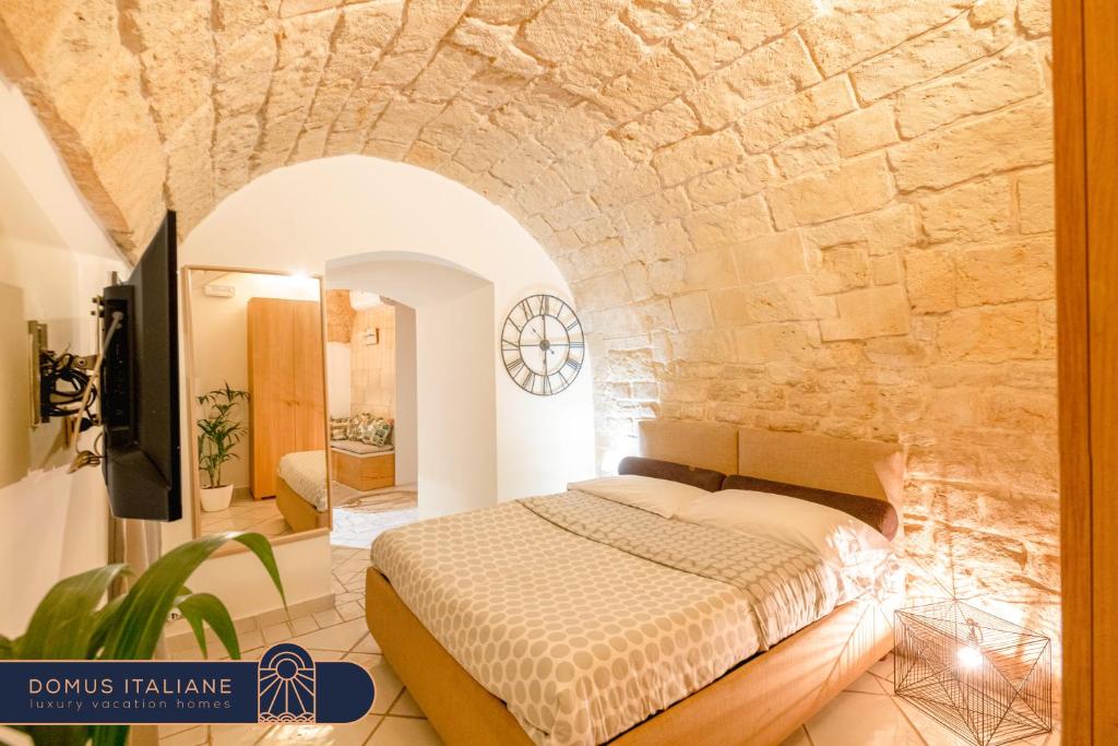 1 dormitorio con cama y pared de piedra en Cozy house in the old city, en Bari