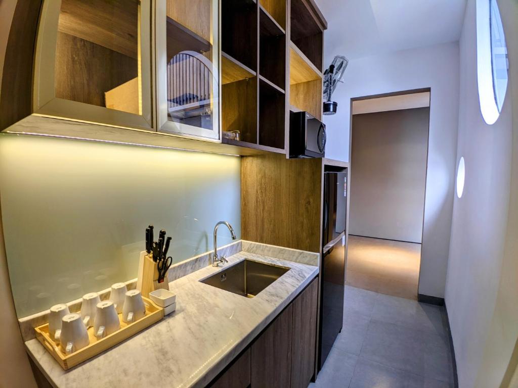 a kitchen with a sink and a counter at The Mango Suites by Flat06 in Jakarta