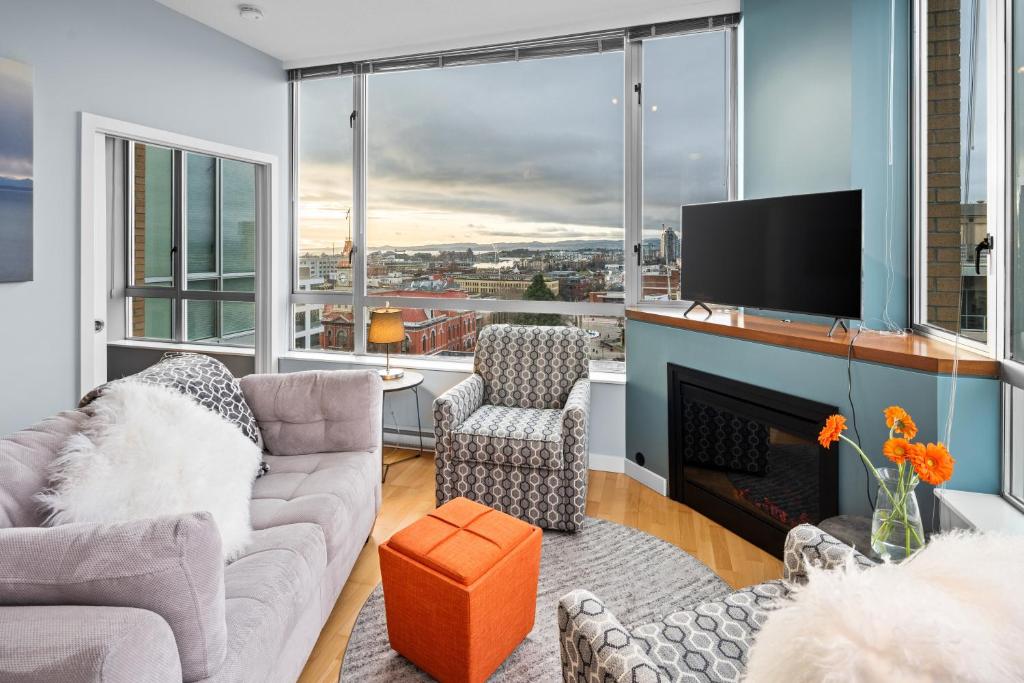 Corazon City Suite by Iris Properties! في فيكتوريا: غرفة معيشة مع أريكة وتلفزيون ومدفأة