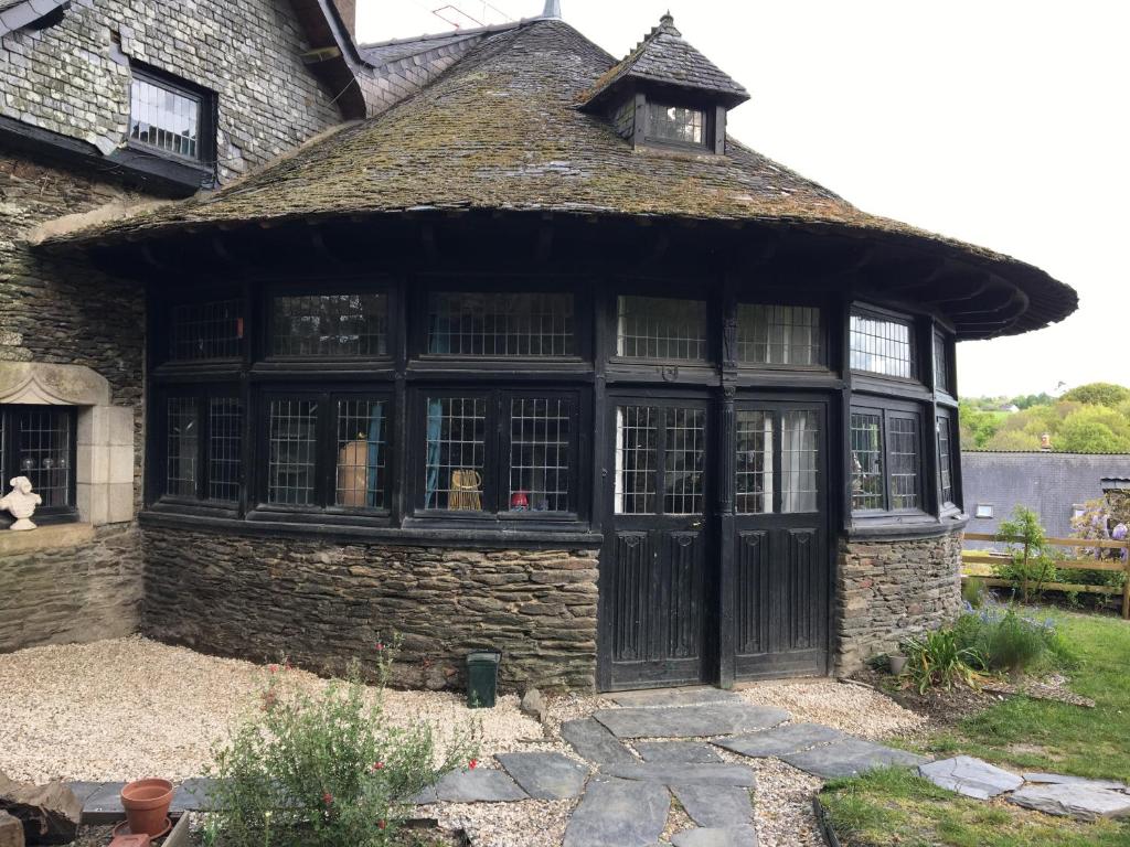una casa vieja con una gran puerta negra en Bed and Breakfast à Rochefort-en-Terre, en Rochefort-en-Terre