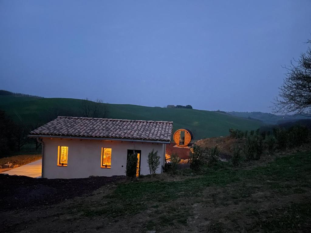 une petite maison sur une colline avec ses lumières allumées dans l&#39;établissement L&#39;Annexe de La Grande Oasis, à Grazac