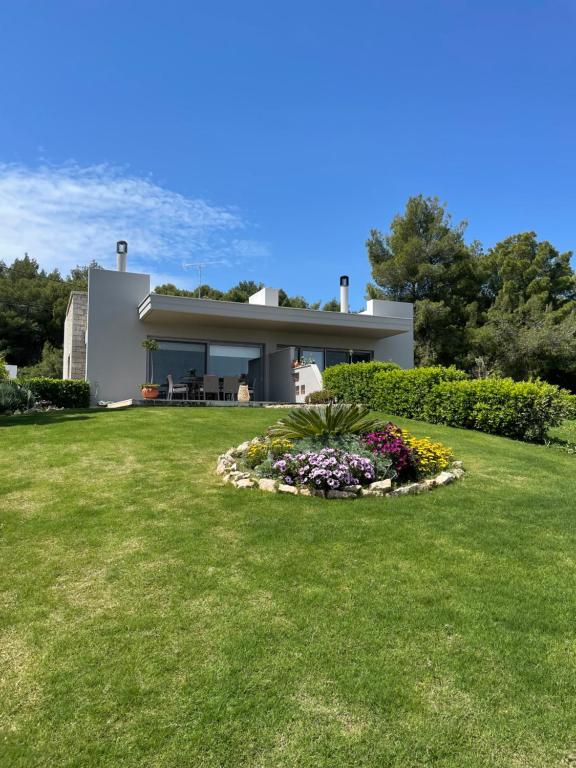 a house with a garden in front of it at Ether Villa in Theologos