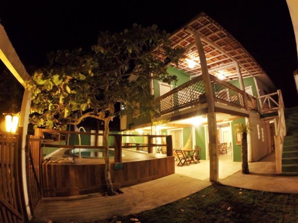 una casa con un árbol delante de ella por la noche en Pousada Vila Mundi Itaúnas en Itaúnas