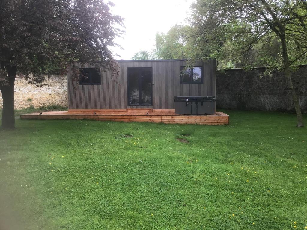 une petite maison dans une cour avec une pelouse dans l'établissement Hôtel Le Saint Martin, à Sablé-sur-Sarthe