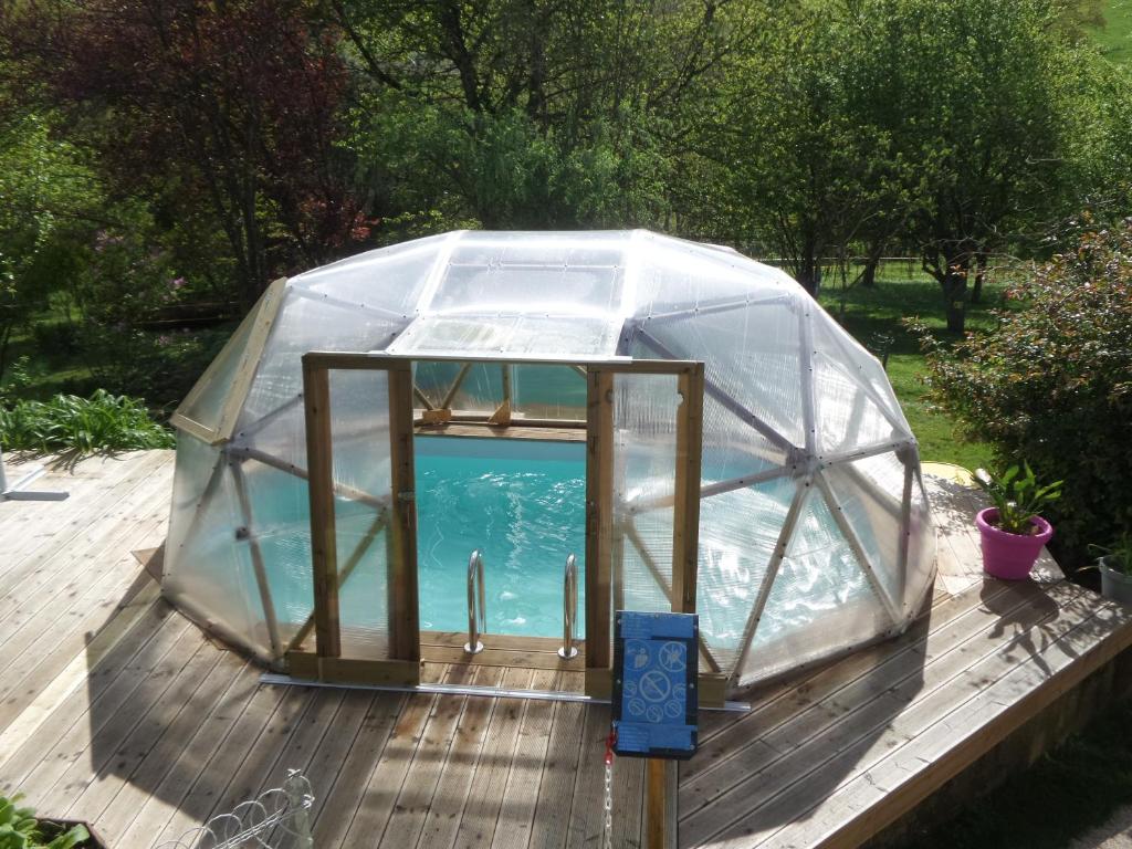 a greenhouse with a pool in it on a deck at Gite les Courtaillards in Couches