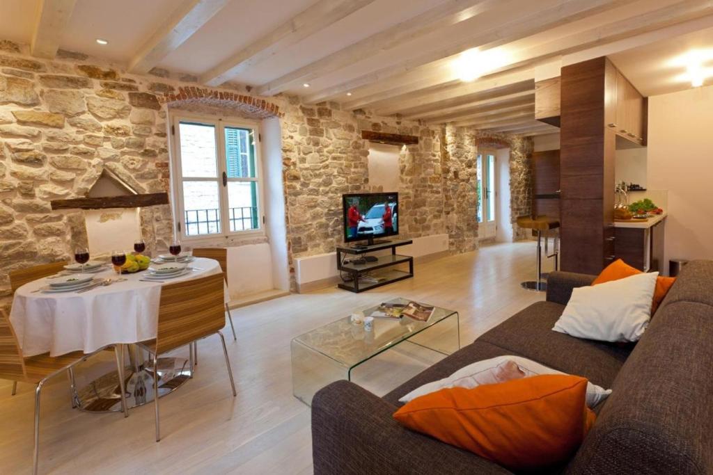 ein Wohnzimmer mit einem Sofa und einem Tisch in der Unterkunft Luxury San Giovanni Apartment 2 in Split
