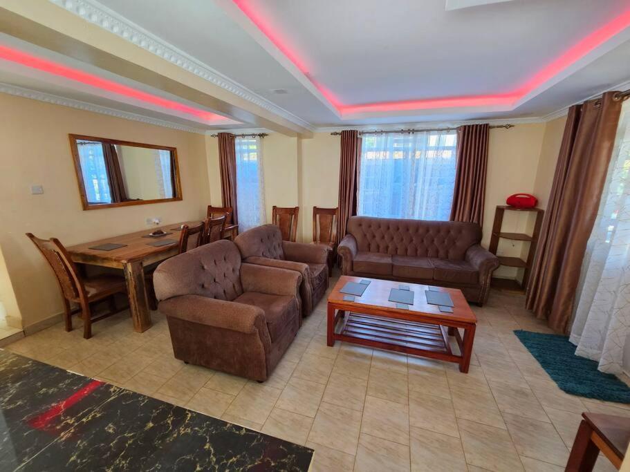 a living room with two couches and a table at The Barn Entire 3 Bed House Self catering in Ruaka