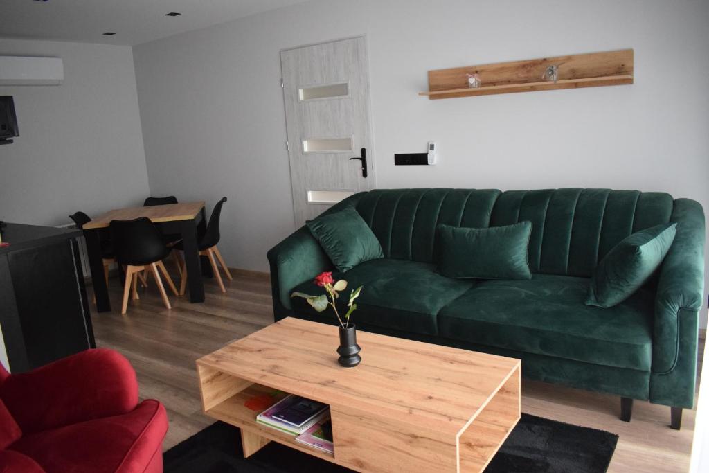 uma sala de estar com um sofá verde e uma mesa de centro em Country Rooms em Bachowice