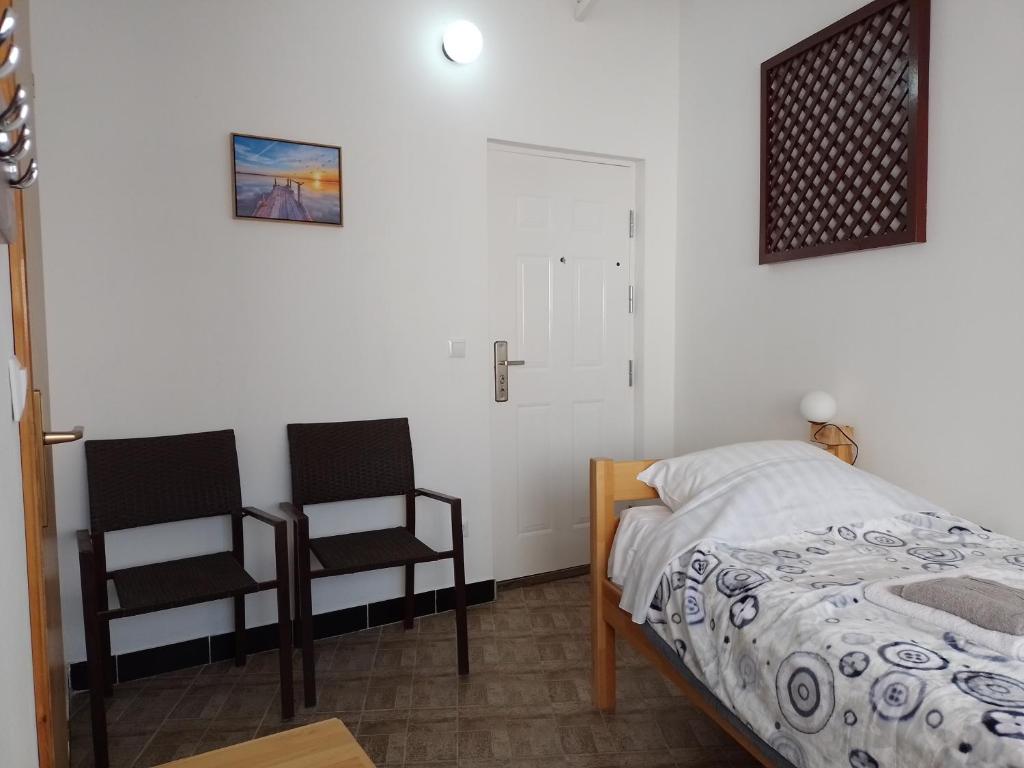 a bedroom with two chairs and a bed at TRIO sobe in Jajce