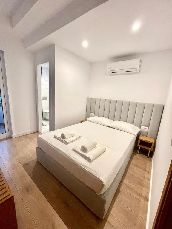 um quarto com uma grande cama branca em um quarto em Hotel Aulona em Sarandë