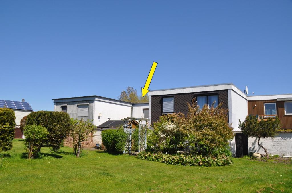 a house with a yellow arrow on top of it at Westerbergen Haus "leucht blick" in Westfehmarn