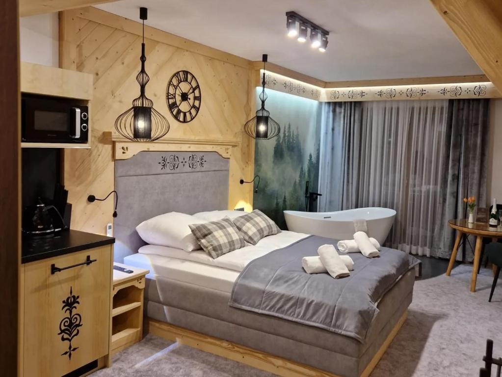 1 dormitorio con 1 cama con bañera y lavamanos en Apartamenty Małe Ciche, en Małe Ciche