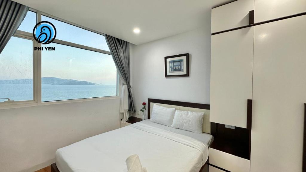 - une chambre avec un lit et une grande fenêtre dans l'établissement Phi Yen Muong Thanh 04 Apartment, à Nha Trang