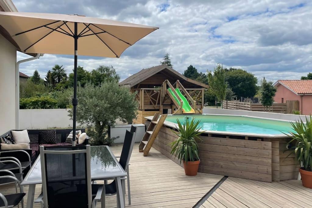 un patio avec une piscine et un parasol dans l'établissement Magnifique villa avec piscine et cabane, à Saubrigues
